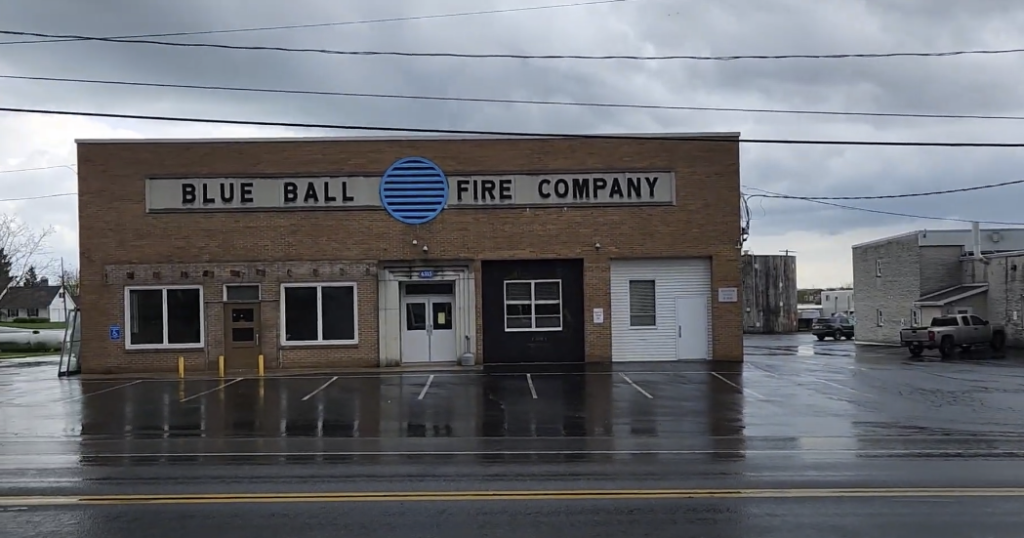 Front view of a building with a "Blue Ball Fire Company" sign near the top.