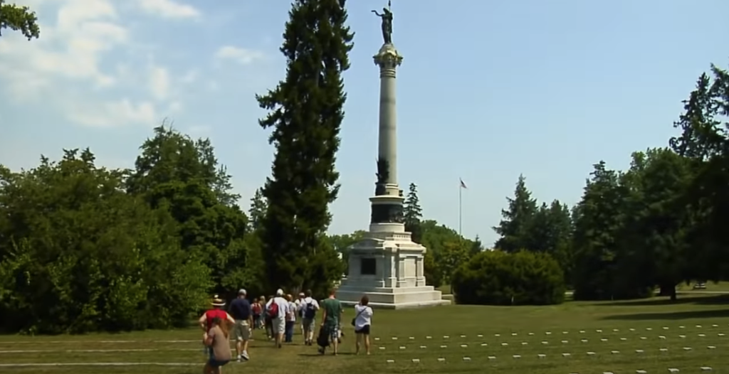 Gettysburg Park with tall statue and people walking on grass