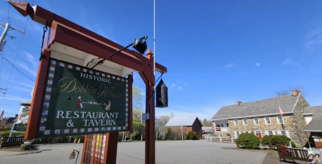 Green road sign of 'Dobbin House Restaurant and Tavern' with the destination visible in the distance